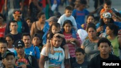 FILE - Hundreds of Central American migrants walk together on the highway, after crossing the Guatemala – Mexico border, near Ciudad Hidalgo, Mexico, June 5, 2019.