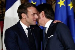 FILE - In this Thursday, Feb. 27, 2020 file photo, French President Emmanuel Macron, left, puts his arm around the shoulder of Italian Premier Giuseppe Conte and gives him a kiss on both cheeks. (AP Photo/Andrew Medichini, File)