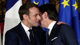 FILE - In this Thursday, Feb. 27, 2020 file photo, French President Emmanuel Macron, left, puts his arm around the shoulder of Italian Premier Giuseppe Conte and gives him a kiss on both cheeks. (AP Photo/Andrew Medichini, File)