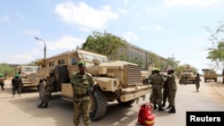 FILE - Burundian African Union Mission in Somalia peacekeepers stand next to an armored vehicle as they prepare to leave the Jaale Siad Military Academy after being replaced by the Somali military in Mogadishu, Somalia, Feb. 28, 2019.