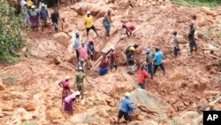 Warga menggali gundukan tanah untuk mencari seorang anak yang terkubur lumpur pasca Siklon Tropis Idai melanda kota Chimanimani, Zimbabwe, Selasa (19/3).