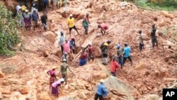 A family digs for their son who got buried in the mud when Cyclone Idai struck in Chimanimani about 600 kilometers (375 miles) southeast of Harare, Zimbabwe, March, 19, 2019. 