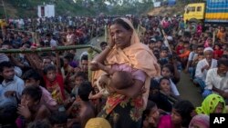 A Rohingya Muslim woman, who crossed over from Myanmar into Bangladesh, waits to receive aid with hundreds of other displaced Rohingyas, near Balukhali refugee camp, Bangladesh, Sept. 25, 2017.