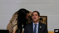 Juan Guaido, right, President of National Assembly and self-proclaimed interim president speaks with lawmaker Delsa Solorzano during a session of the National Assembly in Caracas, Venezuela, Tuesday, April 2, 2019.