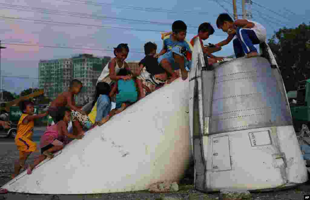 Anak-anak Filipina bermain di bekas pesawat McDonnell Douglas DC-9, yang diletakkan di sebuah tanak kosong dekat rumah mereka di pinggiran kota Paranaque, selatan Manila, Filipina.