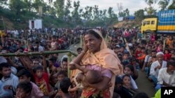 A Rohingya Muslim woman, who crossed over from Myanmar into Bangladesh, wipes her sweat as she waits to receive aid during its distribution near Balukhali refugee camp, Bangladesh, Sept. 25, 2017. 