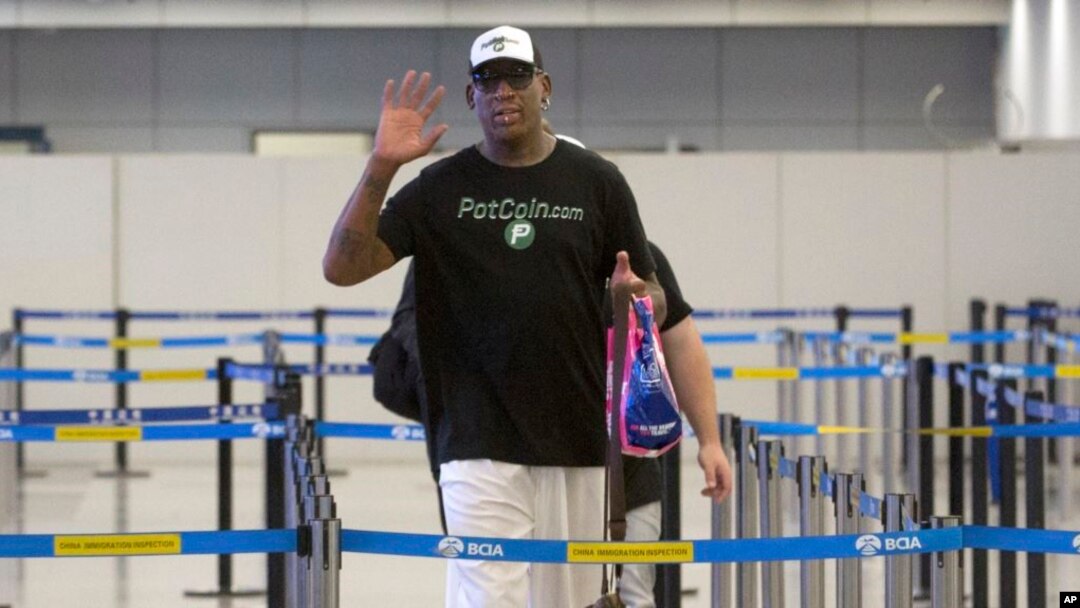 Mantan pemain basket NBA Dennis Rodman memberi isyarat kepada fotografer saat ia bersiap untuk pergi melalui imigrasi di Bandara Internasional Ibu Kota Beijing di Beijing, Selasa, 13 Juni 2017. (AP Photo/Mark Schiefelbein)