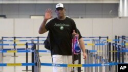 Mantan pemain basket NBA Dennis Rodman memberi isyarat kepada fotografer saat ia bersiap untuk pergi melalui imigrasi di Bandara Internasional Ibu Kota Beijing di Beijing, Selasa, 13 Juni 2017. (AP Photo/Mark Schiefelbein)