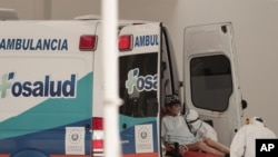 Un paciente infectado con el nuevo coronavirus es trasladado de una ambulancia a una camilla en la entrada de emergencia del Hospital Nacional en San Salvador, El Salvador, el viernes 7 de agosto de 2020.