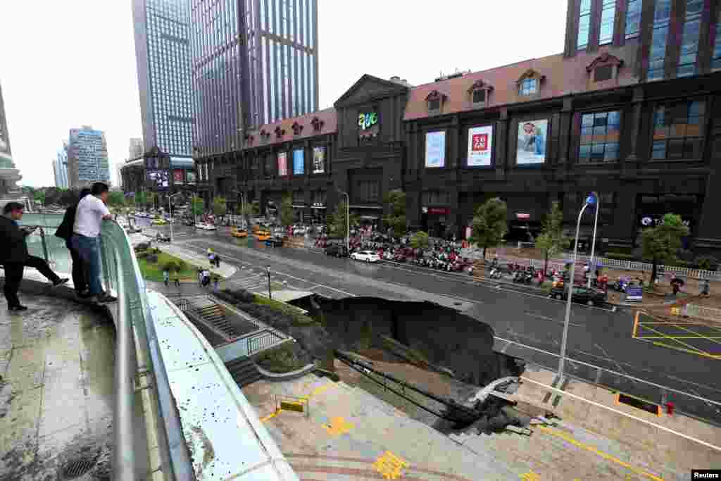 People look at the part of road that collapsed in Nantong, Jiangsu province, China, June 10, 2017.