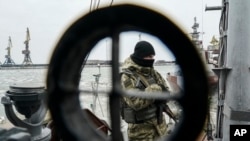FILE - A Ukrainian serviceman stands on board a coast guard ship in the Sea of Azov port of Mariupol, eastern Ukraine, Dec. 3, 2018.