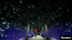FILE - New York's climate change museum will have only two rivals. One is the Klimahaus (Climate House) in Bremerhaven, Germany. In one of its exhibits, shown above, a man looks at an artificial starry sky.