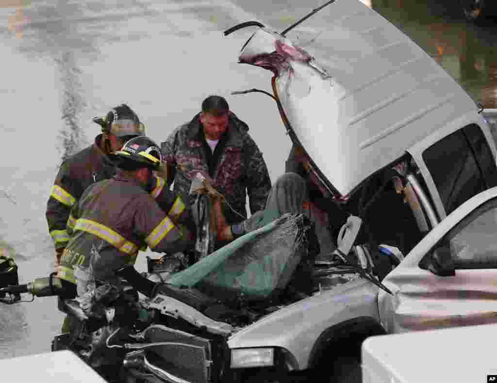 First responders work to free a passenger from a truck involved in an accident on Interstate 35 during severe weather in Moore, Oklahoma, May 6, 2015.