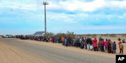 This Jan. 14, 2019, photo released by U.S. Customs and Border Protection shows some of the 376 Central Americans the Border Patrol says it arrested, the vast majority of them families who had dug holes to cross into the United States, about 10 miles east of San Luis, Ariz.