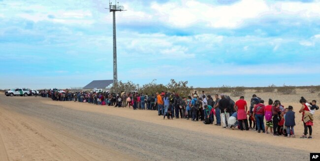 This Jan. 14, 2019, photo released by U.S. Customs and Border Protection shows some of the 376 Central Americans the Border Patrol says it arrested, the vast majority of them families who had dug holes to cross into the United States, about 10 miles east of San Luis, Ariz.