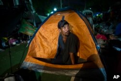 Joel Eduardo Espinar looks out from his family's tent in the main square of Arriaga, Mexico, Oct. 26, 2018. His plan is to request asylum rather than cross the border illegally. “I’m kind of fearful of what will happen once we get to the U.S. border,” he said.