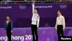 일본 대표 하뉴 유즈루(가운데)가 17일 강릉 아이스아레나에서 평창동계올림픽 피겨스케이팅 남자 싱글 우승 직후 시상대에서 손을 들어올리고 있다. 왼쪽은 은메달 수상자 우노 쇼마(일본), 오른쪽은 동메달 하비에르 페르난데스(스페인).