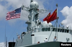 FILE - A sailor in China's People's Liberation Army Navy hoists the Chinese flag after arriving at the Joint Base Pearl Harbor Hickam to participate in the multinational military exercise RIMPAC in Honolulu, Hawaii, June 29, 2016.