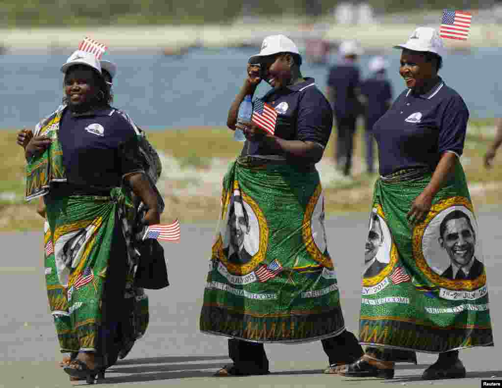 Tanzanian women wearing the local kitenge dress, bearing the image of U.S. President Barack Obama, await the arrival of the President and First lady Michelle Obama in Dar Es Salaam July 1, 2013. REUTERS/Gary Cameron (SOUTH AFRICA - Tags: POLITICS) - RTX1