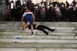 Povređeni demonstrant leži na stepenicama ispred Doma Narodne skuopštine Srbije, tokom sukoba policije i demonstranata, u Beogradu, 7. jula 2020. (Foto: Rojters, Marko Đurica)