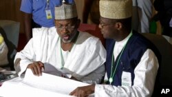 FILE - Independent National Electoral Commission chairman, Attahiru Jega, left, views election results at the coalition center in Abuja, Nigeria, March 30, 2015.