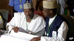 尼日利亚独立的全国选举委员会主席杰加（左）正在审视选票。3月30日摄于首都阿布贾。