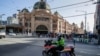 Seorang polisi berpatroli dengan sepeda motor di Melbourne, 12 Februari 2021, setelah pihak berwenang memerintahkan lockdown selama lima hari di seluruh negara bagian mulai tengah malam waktu setempat untuk mencegah penyebaran virus COVID-19. (Foto oleh Con Chronis / AFP)