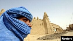 Nómada tuaregue ao lado da centenária mesquita de Tumbouctou no norte do país 