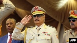 Le maréchal Khalifa Haftar, au centre, salue le chef d'état-major de l'armée nationale libyenne Abdelrazak al-Nadhuri, à droite, et l'ancien Premier ministre libyen Abdullah al-Thani, chef du gouvernement à Bayda, lors d’une parade militaire à Benghazi, L