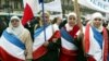 Perempuan Muslim yang mengenakan bendera Perancis berbaris di Paris saar protes undang-undang baru yang melarang simbol-simbol agama di sekolah-sekolah negeri Prancis, 14 Februari 2004. (Foto: Reuters)
