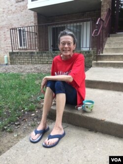 Cindy, who was homeless for eight years, sits in front of the building where she now has an apartment she can call her own, thanks to StreetLight Community Outreach Ministries.