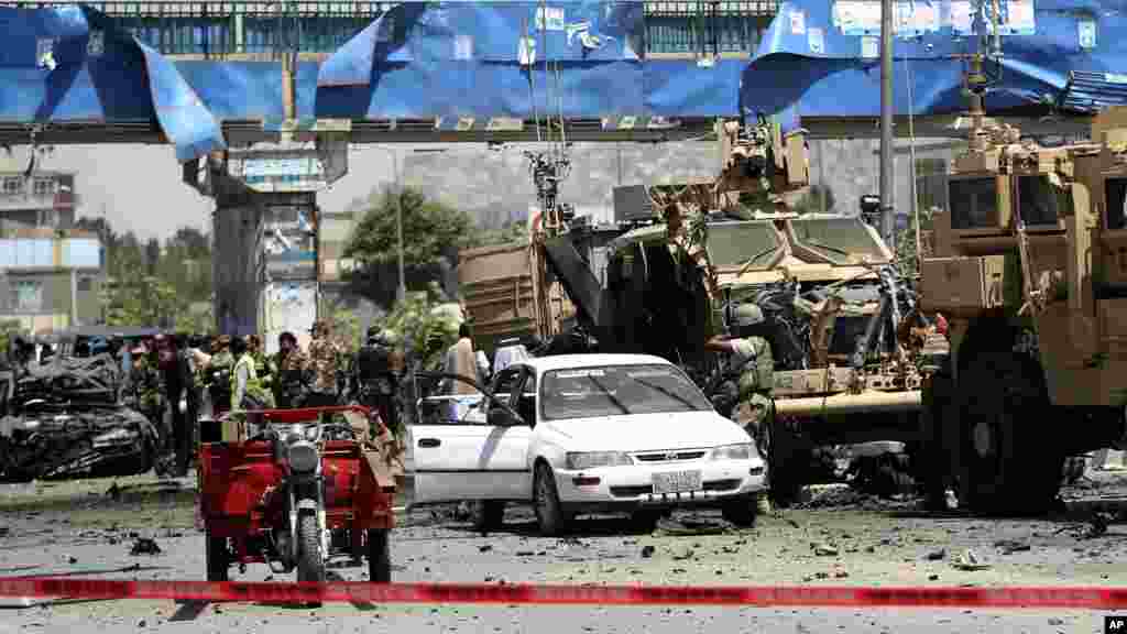NATO and Afghan security forces inspect the site of a suicide attack in Kabul, Afghanistan, Aug. 10, 2014. 