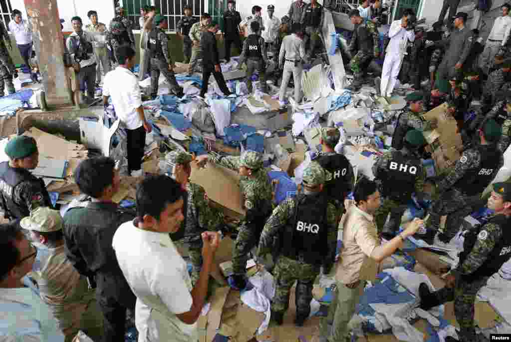 Rescue workers and soldiers search through a site of the accident in a shoe factory in Phnom Penh, May 16, 2013.