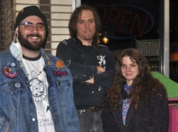 Nic White, Tyler Bowen, dan Magena Morris berpose di depan tempat donasi yang mereka bangun untuk mengumpulkan barang-barang bagi para tunawisma di Charlotte, North Carolina, 21 Januari 2021. (Foto: Ruthie Howe)