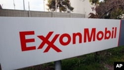 FILE - The sign for the Exxon Mobil Torrance Refinery in Torrance, Calif., Jan. 30, 2012. On Wednesday, Exxon Mobil shareholders pushed the company to share more information about whether regulations designed to reduce climate change will hurt the oil giant's business.