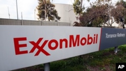 FILE - The sign for the Exxon Mobil Torrance Refinery in Torrance, California.