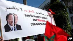 FILE - Protesters hold a banner and the Moroccan flag at a rally in Rabat, Morocco, as they accuse U.N. Secretary-General Ban Ki-moon of "abandoning neutrality, objectivity and impartiality" during a recent visit to Western Saharan refugee camps in southe