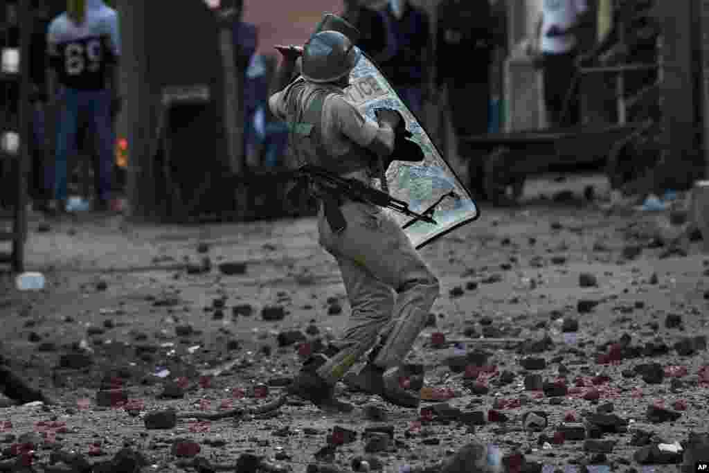 An Indian paramilitary soldier tries to avoid stones thrown at him by Kashmiri protesters during a protest in Srinagar, Indian-controlled Kashmir.