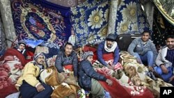 Egyptian migrant workers lie under blankets in a makeshift open-air camp at Tripoli International Airport in Libya, March 1, 2011