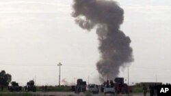 In this image made from video, smoke rises from an explosion as Iraqi forces, Shiite militiamen and Sunni tribal fighters battle Islamic State militants for control of Tikrit, Iraq, Tuesday, March 3, 2015.