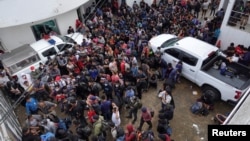 Migrantes que fueron interceptados por las autoridades mexicanas mientras viajaban en dos remolques en una vía en el estado de Veracruz se hospedan en las instalaciones de la Procuraduría General de la República, en Coatzacoalcos, México, el 19 de noviembre de 2021.