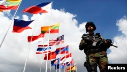 A member of government security holds his weapon at the VIP section of Phnom Penh airport as delegations arrive for the 21st ASEAN (Association of Southeast Asian Nations) and East Asia summits in Phnom Penh, file photo. 