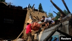 在湖南涟源，暴雨后，灾民从倒塌的房子里搬东西（2017年7月3日）