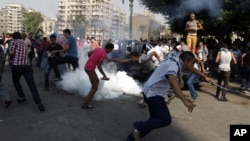 Manifestantes egipcios huyen de los gases lacrimógenos cerca de la embajada de Estados Unidos en el Cairo, el jueves 13 de septiembre.