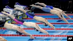 Swimmers competing in the 2016 FINA World Swimming Championships dive into the pool in Windsor, Ontario. (AP Photo/David J. Phillip)