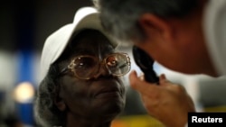 FILE - Gloria Thompson, 68, receives an eye exam at the Care Harbor/LA free clinic in Los Angeles, Sept. 27, 2012. 