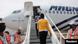 Haitian migrants board a plane as part of the "assisted voluntary return" to Haiti by Mexican authorities, at the Carlos Rovirosa Perez International airport, in Villahermosa, Mexico, Sept. 29, 2021.