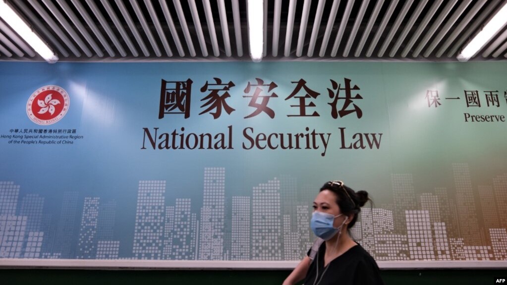 行人走过香港街头港版国安法的宣传牌。（2020年7月28日）(photo:VOA)