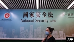 行人走過香港街頭港版國安法的宣傳牌。（2020年7月28日）
