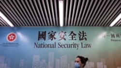 行人走过香港街头港版国安法的宣传牌。（2020年7月28日）